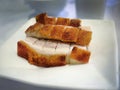 Selective focus, focus on foreground, close up, Crunchy, sliced crispy roasted pork belly on white plate, Cantonese Style food Royalty Free Stock Photo
