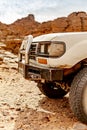 Four wheels drive 4x4 car front side view in Sahara desert rocky Tassili n'Ajjer Tadrart Rouge. Royalty Free Stock Photo