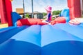 Selective focus on foreword edge of a bouncy house with blurred children playing in the background Royalty Free Stock Photo