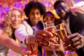 Selective focus of four happy, diverse friends toasting with glasses of champagne at a nightclub Royalty Free Stock Photo
