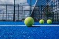 Selective focus, four paddle tennis balls on a blue paddle tennis court close to the net Royalty Free Stock Photo