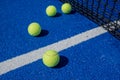 Selective focus, four paddle tennis balls on a blue paddle tennis court close to the net Royalty Free Stock Photo