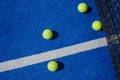 Selective focus four paddle tennis balls on a blue paddle tennis court with a net in the background Royalty Free Stock Photo