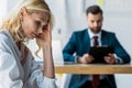 Focus of frustrated blonde employee near recruiter in suit