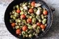 Brussels sprouts with vegetables and herbs in a pan. Cooking Brussels sprouts. Vegan food. Selective focus. Royalty Free Stock Photo