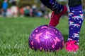 Selective focus on girls' soccer ball with a player on the grass field. Royalty Free Stock Photo