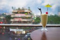 Selective focus on glass of juice against street cityscape on background. Concept of spending leisure time on cafe to enjoy city v