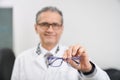 Selective focus of glasses in hands of oculist in clinic