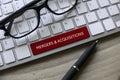 Selective focus of glasses, pen and computer keyboard with red key written with Mergers and Acquisitions on a wooden background