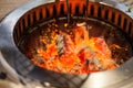 Selective focus on Glowing and Flaming hot natural wood charcoal lump in food restaurant BBQ grill stove background. Natural Heat