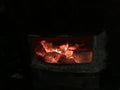 Selective focus on Glowing and flaming hot natural wood charcoal lump in street food BBQ grill stove background. Energy power heat
