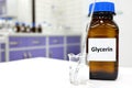 Selective focus of glycerin glass bottle in a white laboratory background with copy space.