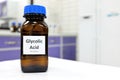 Selective focus of glycolic acid liquid solution in dark brown glass bottle in a white chemistry laboratory background.