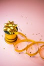 selective focus, gold gift ribbon on pink background, copyspace