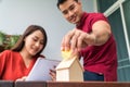 Selective focus of golden coin. Happy Asian couples smiling Because it is profitable from investment And have savings for buying a