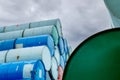 Selective focus on green old chemical barrels stack. Steel tank of flammable liquid. Hazard chemical barrel. Industrial waste.