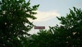 Selective focus on green trees with a Hotel sign board. Royalty Free Stock Photo