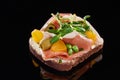 Selective focus of ham and olives on cooked danish smorrebrod sandwich on black.