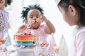 Selective focus on hand of African little child girl holding jelly, enjoy eating rainbow cake on birthday party with fork. Kids Royalty Free Stock Photo