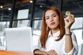 Selective focus on hand of Asian business woman holding cryptocurrency golden bitcoin coin in office. Virtual money on digital.