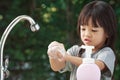 Selective focus hand,Asian girl aged 4 to 8 years old,washing her hands with soap from the tap.Clean her hands Frequent hand washi Royalty Free Stock Photo