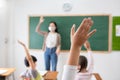 Selective focus on hand. Children or Schoolkids or students raising hands up with Asian teacher wearing protective face mask in
