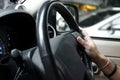 Selective focus on hand of driver on steering wheel of car Royalty Free Stock Photo