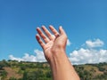 Selective Focus of A Hand Reaching Out Towards the Sky with Blurred Sky Background Royalty Free Stock Photo