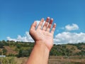 Selective Focus of A Hand Reaching Out Towards the Sky with Blurred Sky Background Royalty Free Stock Photo