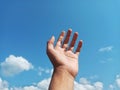 Selective Focus of A Hand Reaching Out Towards the Sky with Blurred Sky Background Royalty Free Stock Photo