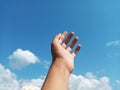 Selective Focus of A Hand Reaching Out Towards the Sky with Blurred Sky Background Royalty Free Stock Photo