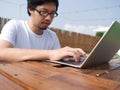 Selective focus on hands of asian man typing on keyboard of laptop. Royalty Free Stock Photo