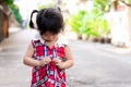 Selective focus hands girl. Child in red dress is buttoning shirt. Asian children try to wear clothes.