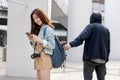 Selective focus on hands of pickpocket thief stealing wallet from backpack of tourist girl