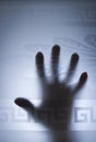 Selective focus - hands silhouette behind a frosted glass door. The concept of fear, danger