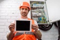 Focus of handsome electrician showing digital Royalty Free Stock Photo