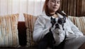 Selective focus. Happy Asian housewife fondling boston terrier with pleasure. Copy space, family concept