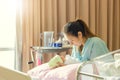 Selective focus of Happy asian mother looking newborn baby boy sleeping in hand at hospital Royalty Free Stock Photo