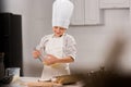 selective focus of happy boy in chef hat and apron whisking eggs in bowl at table