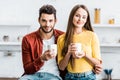 Selective focus of happy couple holding cups Royalty Free Stock Photo