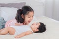 Selective focus happy cute big sister playing with adorable newborn baby brother in morning after waking up. elder sister teasing Royalty Free Stock Photo