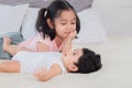 Selective focus happy cute big sister playing with adorable newborn baby brother in morning after waking up. elder sister teasing Royalty Free Stock Photo