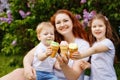 Selective focus. A happy family holds an open-air ice cream in front of them in a spring park against the background of blooming