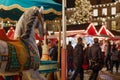 Selective focus at horse carousel and background of night atmosphere of Christmas market.