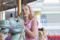 Selective focus of horse on Carousel that Caucasian senior woman ride on at amusement park Royalty Free Stock Photo