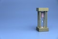 Selective focus of hourglass or sand clock isolated on a blue background with a copy space