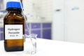 Selective focus of hydrogen peroxide solution in brown amber bottle. Blur laboratory background with copy space.