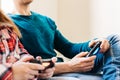 Selective focus image on the hands of a gamer man with a joystick, playing video games with a woman at home, family game concept, Royalty Free Stock Photo