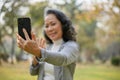 selective focus image, Happy 60s aged Asian woman is taking a selfie with her smartphone Royalty Free Stock Photo