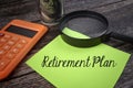 Selective focus image of magnifying glass calculator and bank note with Retirement Plan wording on a wooden background. Business